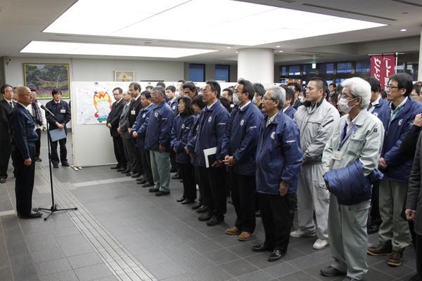 職員たちが並んで市長の話を聞いている写真